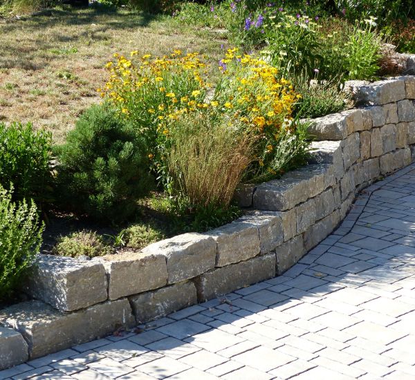 Gartenmauer aus Pflastersteinen und Metall als Sichtschutz